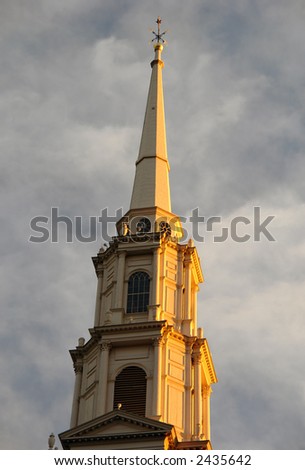 At the break of day the steeple of the Park Street Church glows orange with the rising sun