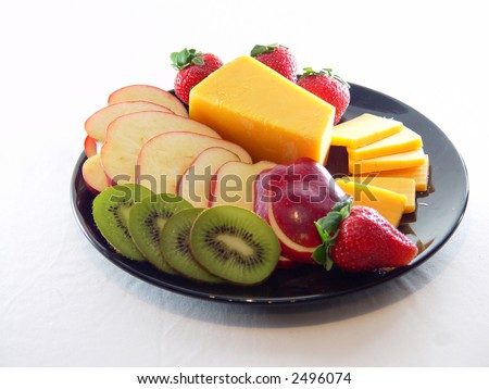 Cheese, strawberries, apples, and kiwi on black tray.