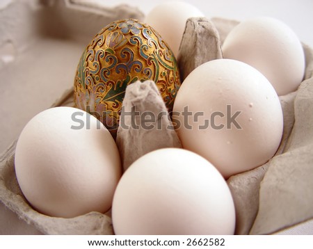 Golden egg with half dozen white cage free  eggs.