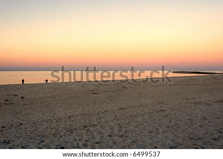 Sunset on Crane\'s beach in Ipswich Massachusetts with people at the shore