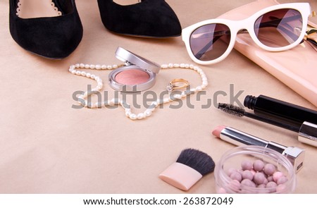 beautiful set of women\'s fashion accessories and cosmetics on a beige background