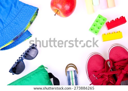 Kid's street outfit and some toys on white background. Overhead view. Place for your text. Frame style.