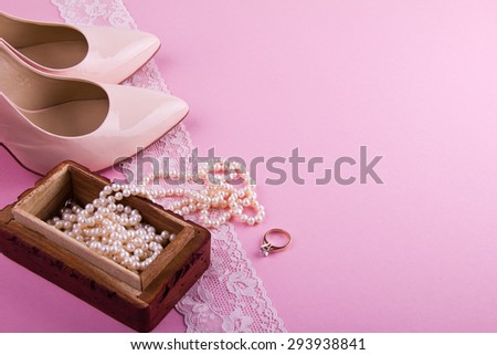 White greeting card with wavy edge. Beige leather shoes with high heel, greeting card and accessories on pink background. Place for your text. Wedding, engagement theme. Good for blogs, instagram.