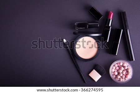 Set of professional cosmetic: make-up brushes, shadows, lipstick, nail polishes on black background. Overhead view. Place for your text. Vignetted.