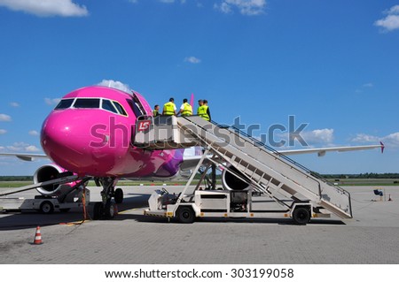 KATOWICE - JULY 2: Cabin crew staff entering the Wizzair Airbus A320 before the flight on July 2, 2015 in Katowice Airport, Poland. Wizzair is one of the largest low-cost airlines.