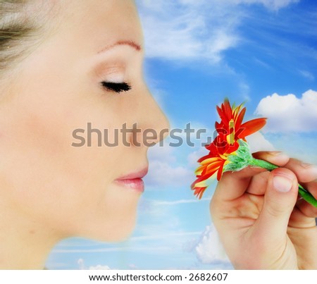 a woman  and a gerbera flower in front of the blue sky - beauty flower