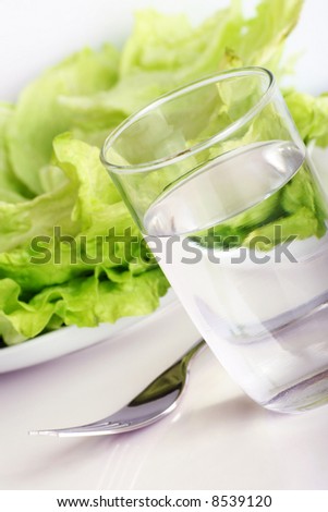 green iceberg salad with a glass of water and a fork