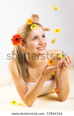 young beautiful woman with a towel and falling flowers