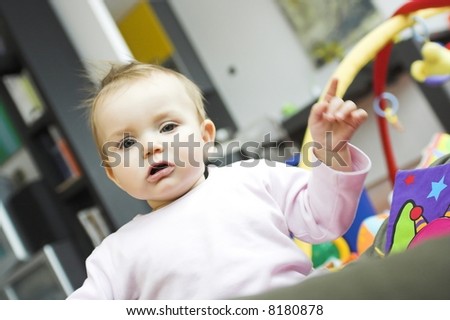 baby playing in a bedroom - hand in the air; showing something
