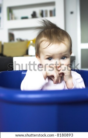 Baby in a plastic tray - sad face expression
