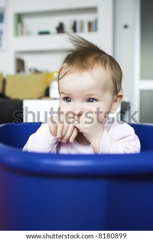 Baby in a plastic tray - sad face expression
