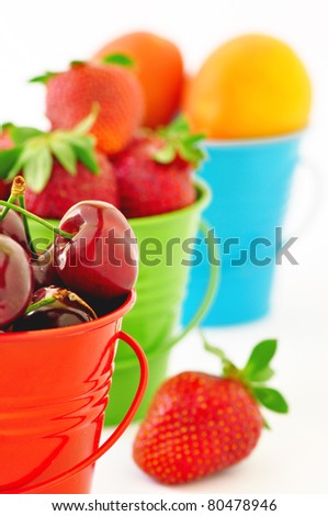 Cherries, strawberries, apricots - Summer fruit in buckets on a white background