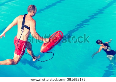 Lifeguard rescue course - lifeguard jumping towards victim. Toned image