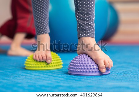 Flat feet correction exercise - Girl walking over spiked half balance massage balls