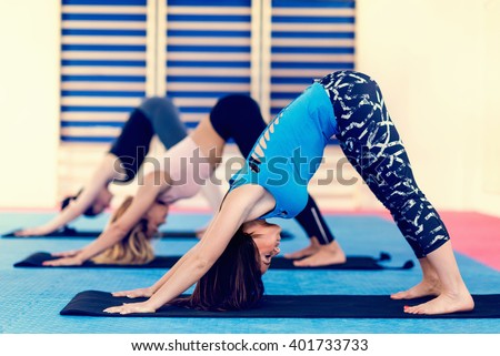 Group of women doing power y, downward facing dog