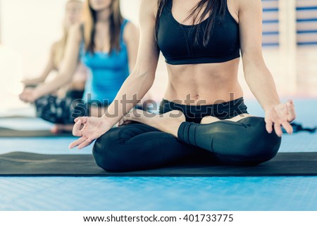 Woman sitting in full lotus position on Yoga class