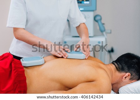 Magnet therapy - Physical therapist placing magnets for treatment of patient\'s back