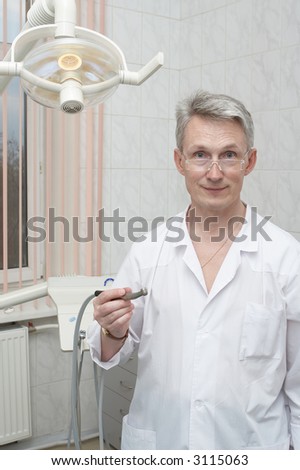Dentist on a workplace at itself in a cabinet