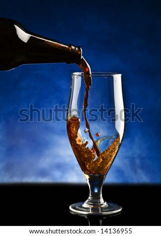 Beer pouring into glass on a black reflect background