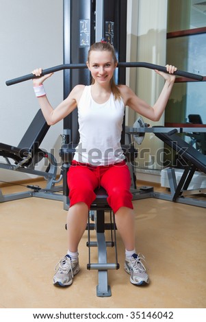 Girl is engaged on a training apparatus in gym