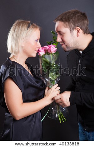 Man and the woman smell a bunch of flowers