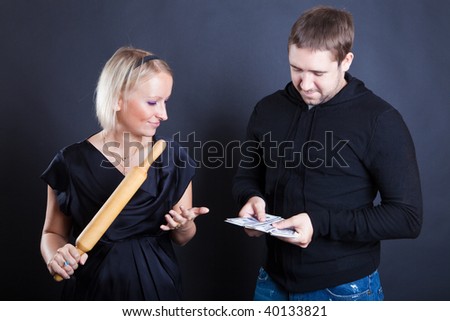 Man counts money, woman costs near to it with a stick in hands