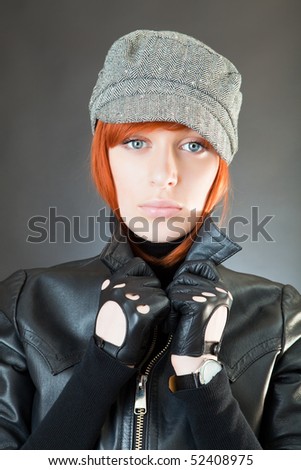 Girl in a suit of the biker against a dark background
