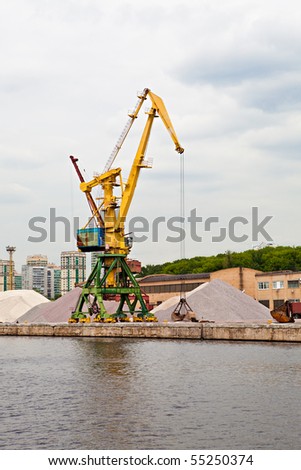 Big crane in port loads gravel