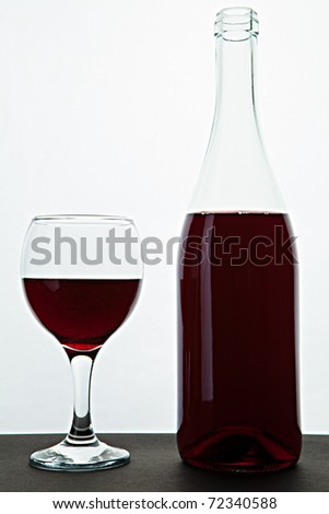 Open bottle and glass with red wine on a table