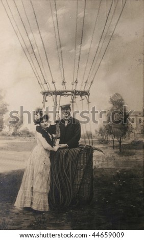 USA-CIRCA 1907: Vintage postcard with loving couple near air balloon. Man standing proudly in basket, woman adoringly next to him, circa 1907.