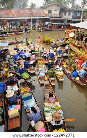 BANGKOK APRIL 13: Wooden boats busy ferrying people at Amphawa floating market on April 13, 2011 in Bangkok. A traditional popular method of buying and selling still practiced in canals , Thailand.