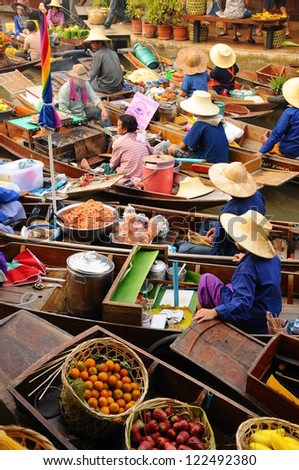 BANGKOK APRIL 13: Wooden boats busy ferrying people at Amphawa floating market on April 13, 2011 in Bangkok. A traditional popular method of buying and selling still practiced in canals , Thailand.