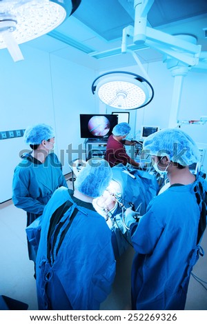 group of veterinarian doctor in operation room for laparoscopic surgical take with blue filter