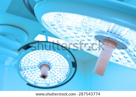 Two surgical lamps in operation room take with blue filter