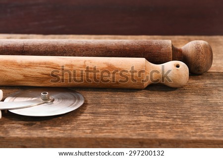 Wooden rolling pin on wooden board.
