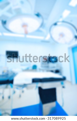 Blur of equipment and medical devices in modern operating room take with art lighting and blue filter
