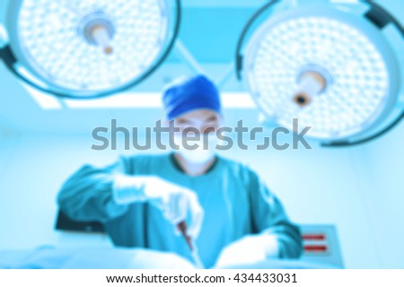 Blur of veterinarian surgery in operation room take with art lighting and blue filter