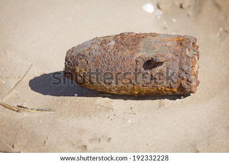 A bomb or shell washed up on a beach. Taken in the UK.