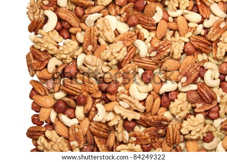 Background of mixed nuts - pecans, hazelnuts, walnuts, cashews, almonds, pine nuts, pistachios, Isolated one edge.