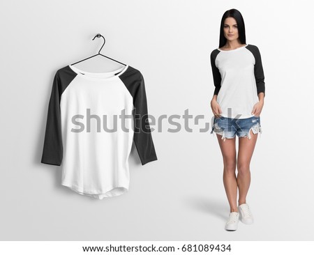 White pullover, long sleeve baseball t-shirt on a young woman in shorts, isolated mockup. Hanging t-shirt long sleeves, against empty wall.