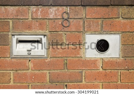 A mailbox in a brick enclosure with an address / name plate for your use, pick up the newspaper, flyers, ads, use as background.