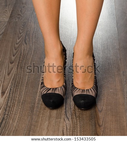 Young woman wearing fashionable shoes at the office - closeup on feet