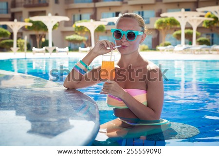 Girl in pool bar at tropical tourist resort vacation destination