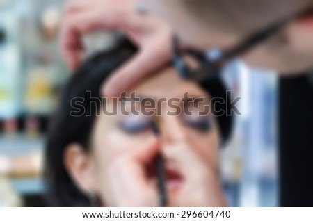 Backstage scene professional Make-up artist doing glamour model makeup at work blur background