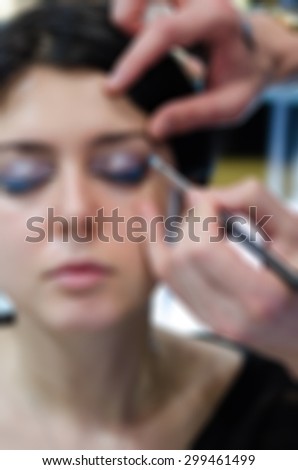 Backstage scene professional Make-up artist doing glamour model makeup at work blur background