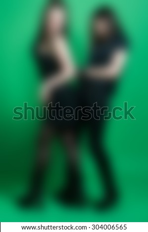 Lesbian gothic women wearing BDSM outfit blur background background with bokeh
