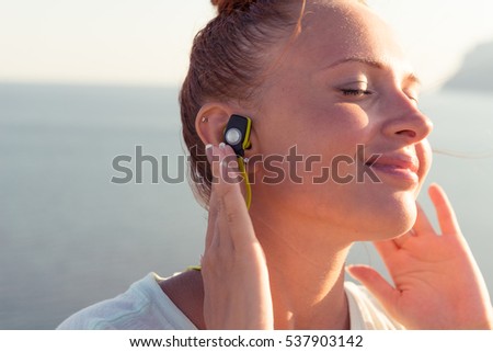 Fitness girl with sport in-ear wireless headphones - Caucasian female athlete woman wearing Bluetooth earphones