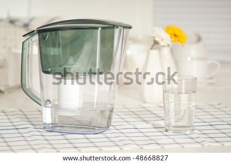Water filter and a glass at the kitchen table