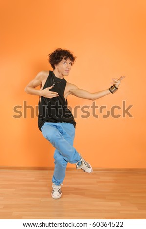 Young man perform break dancing moves on vivid background