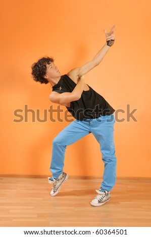 Young man perform break dancing moves on vivid background